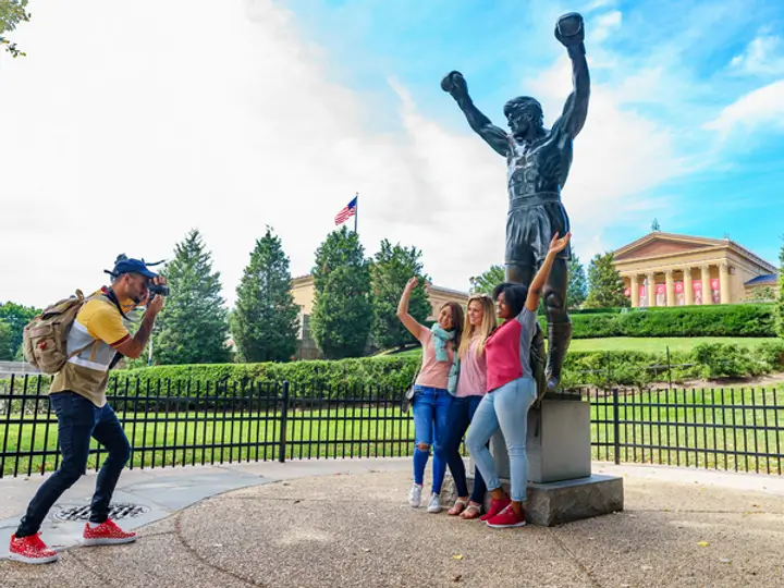 Tourists pose at the 10-foot bronze Rocky statue in Philadelphia (Image credit: Visit Philly)